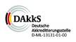 Logo der DAkkS (Deutsche Akkreditierungsstelle) mit konzentrischen Kreisen mit schwarzen, roten und gelben Segmenten und dem Text DAkkS Deutsche Akkreditierungsstelle D-ML-13131-01-00 rechts daneben.